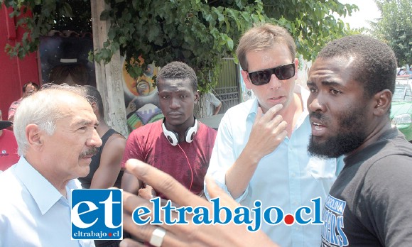 El Alcalde Patricio Freire junto al Dideco Pablo Silva dialogan con dos de los ciudadanos extranjeros afectados por el incendio.