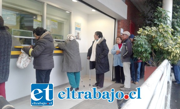 Mujeres adulto mayores con bastones llegan a pagarse.