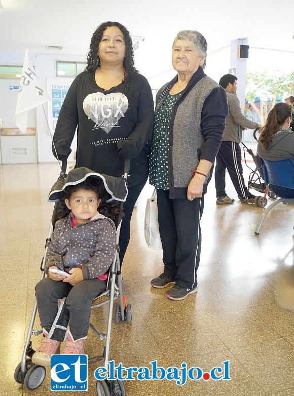 Teresa Oyarce junto a su hija Isabella y su madre Bernardita Araya, utilizando un coche y agradeciendo la iniciativa.
