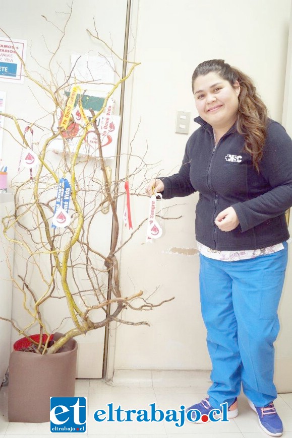 Una profesional dejando su huella en el árbol con la cinta.
