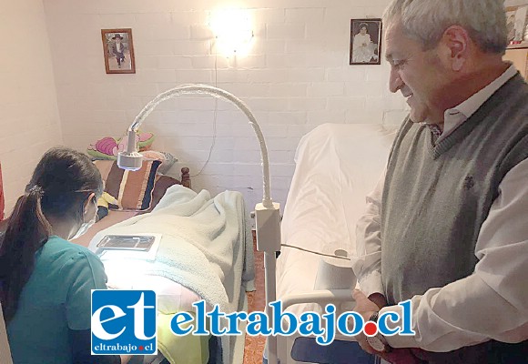 El alcalde Pedro Caballería observa a la funcionaria atendiendo a la paciente postrada en su propia casa, una gran innovación pionera en el valle de Aconcagua.