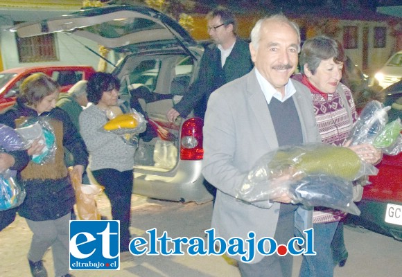 DESCARGANDO.- Vecinos de Población Santa Rosa hicieron entrega de las bufandas y gorros a los usuarios del albergue.