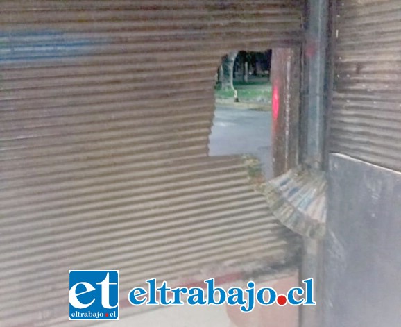 Los delincuentes ingresaron por este forado que le efectuaron a la cortina metálica del local comercial.