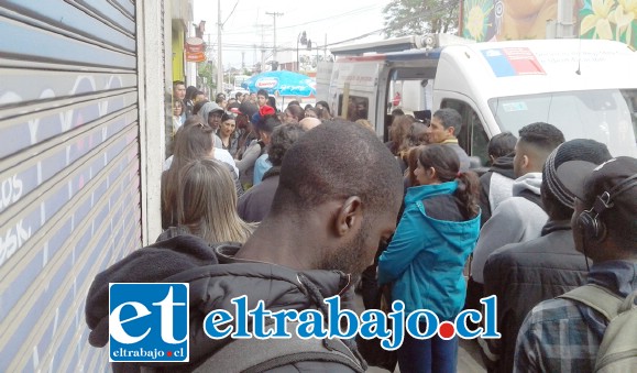 Gran cantidad personas haciendo fila frente a la unidad móvil del Registro Civil.