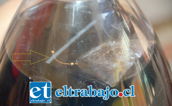 ASCO POR HALLAZGO.- La flecha señala el piercing metálico y la bolsa plástica, ambos objetos flotando en la bebida, el sello de la tapa completamente cerrado y sin señales de haber sido manipulado.