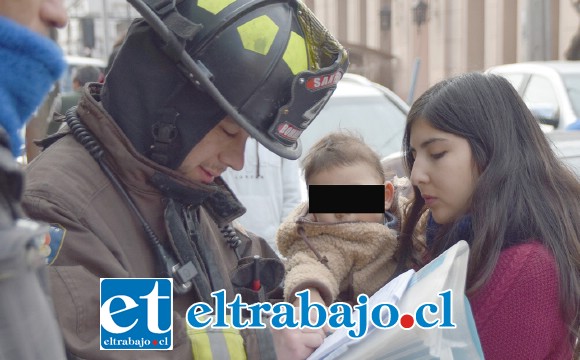 RESCATADO.- La madre del bebé recuperó en pocos minutos a su guagua, mientras que este bombero le tomaba sus datos.