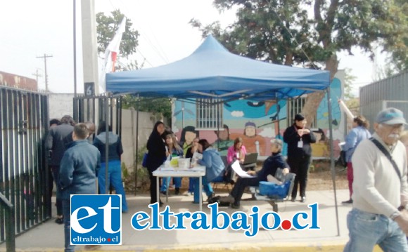 Personal atendiendo, mientras una pareja de adultos mayores ingresa al Cesfam.