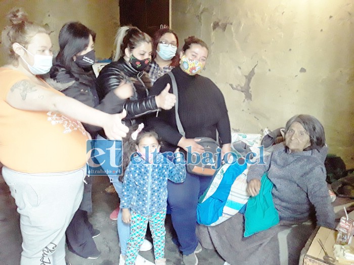 El grupo de voluntarias junto a ‘Charito’ como le dicen cariñosamente, quien está acostada en su cama.
