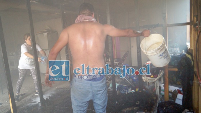 VECINOS SOLIDARIOS.- Con baldes, botellas con agua y lo que tuvieran a la mano, estos vecinos controlaron a tiempo las llamas que consumían esta humilde vivienda en campamento Yevide.